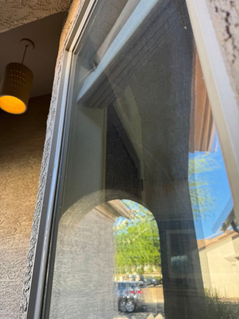 Window view with sheer curtains and outdoor scene, highlighting natural light and texture.