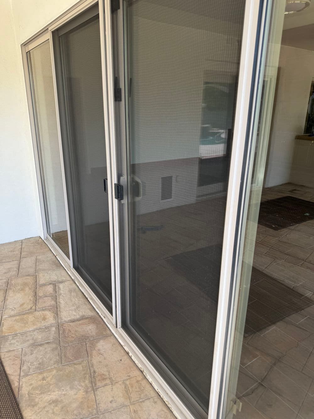 Sliding glass doors with screen, leading to tiled floor interior space.